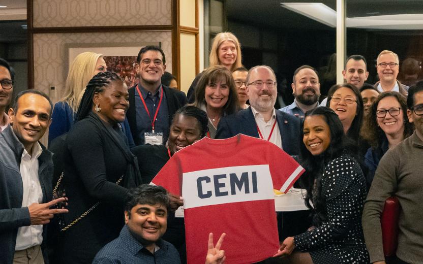 a group of people pose with a CEMI jersey