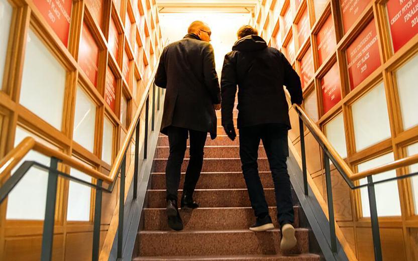 two people ascend stairs together as they talk