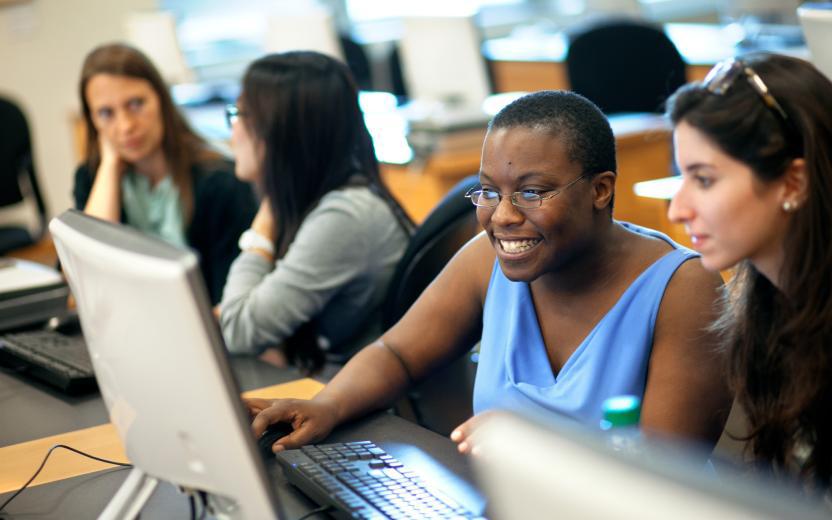 Two people collaborating, using a computer