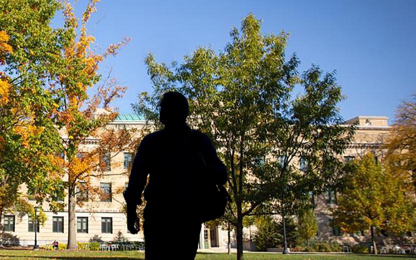 the silhouette of a person walking across the Ag Quad