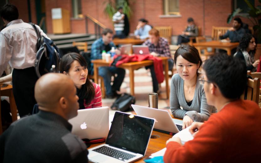 Graduate students with laptops working together