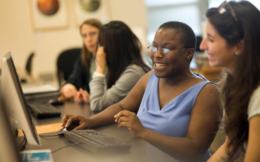 People working at a computer in a Cornell library