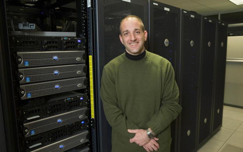 A technician stands in front of a bank of computers