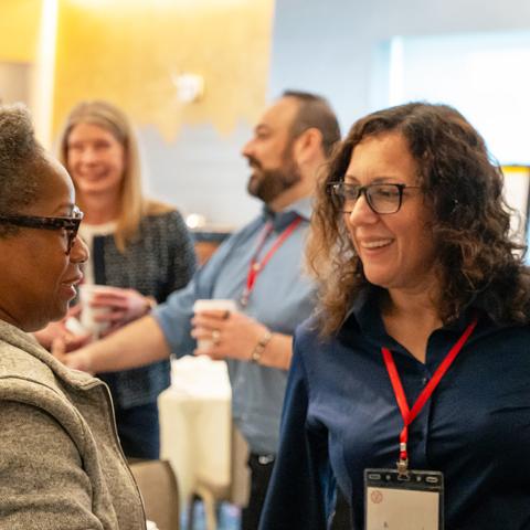 a group of colleagues chat during a workshop break