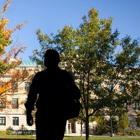 the silhouette of a person walking across the Ag Quad